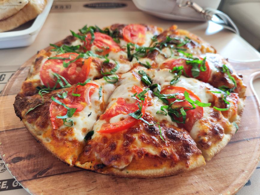 Čerstvá pizza Margherita vytiahnutá z drevenej pece